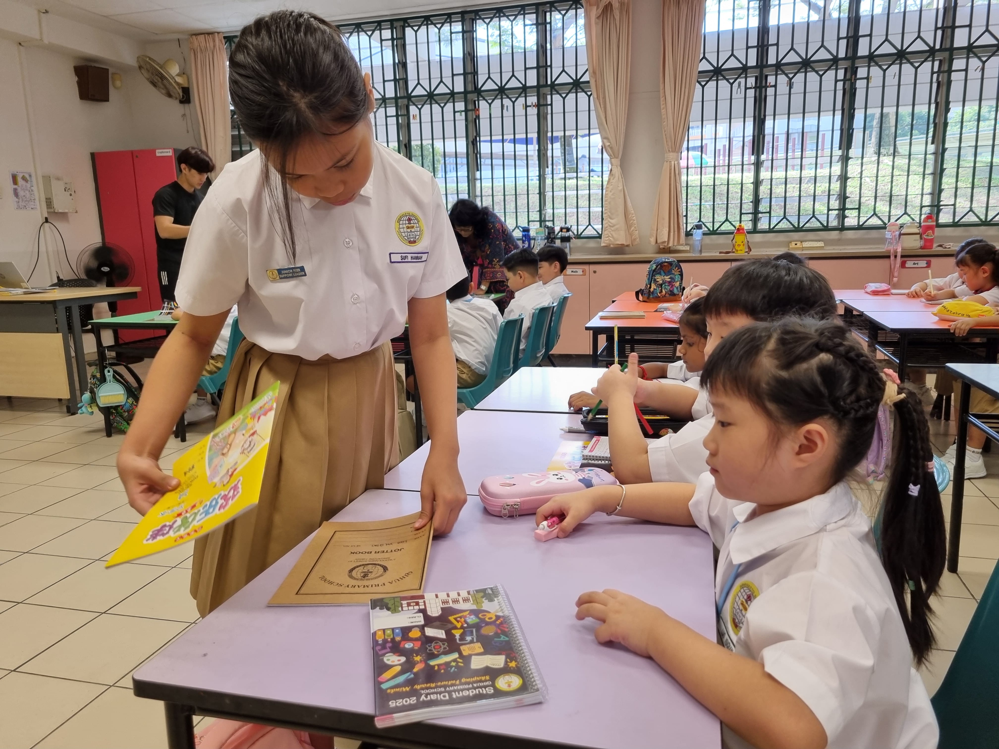 Senior student checking on junior student books